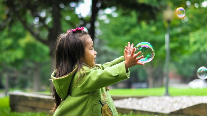 selective photo of a girl holding bubbles